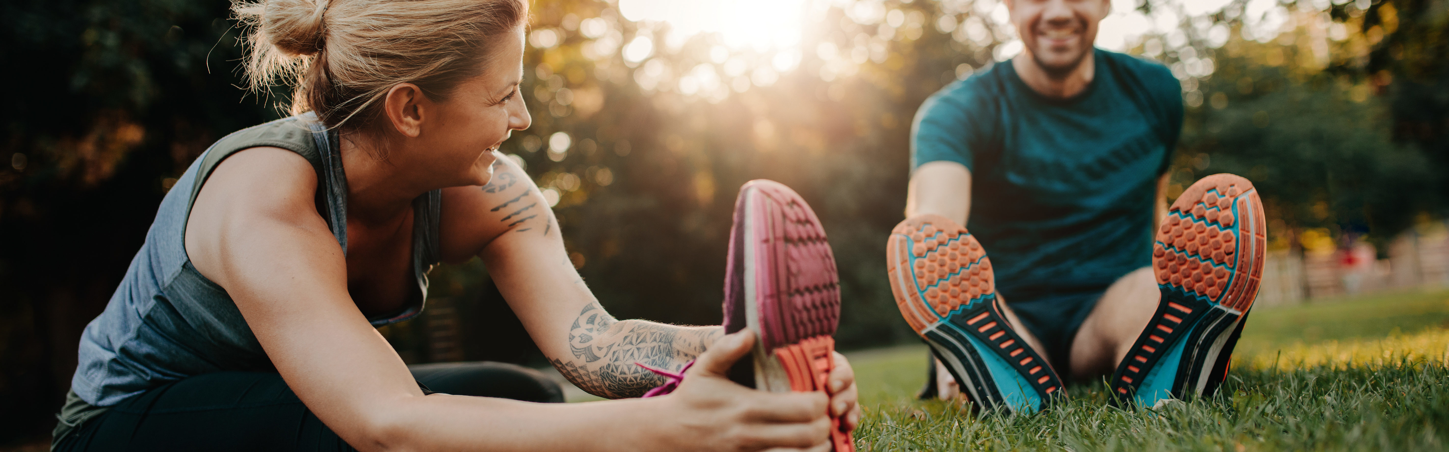 Two people stretching in sunlight.