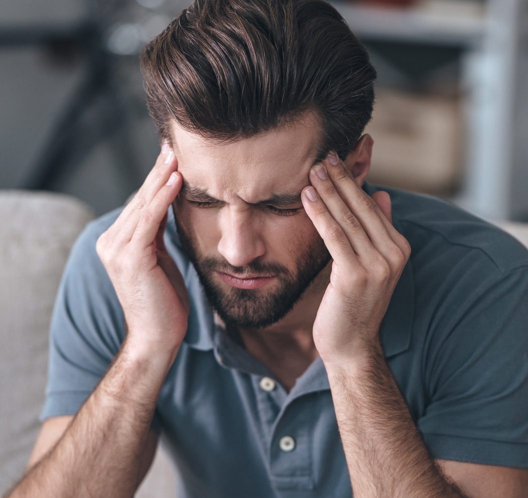 Man experiencing stress or headache.