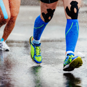 Runners splashing across a wet pavement.